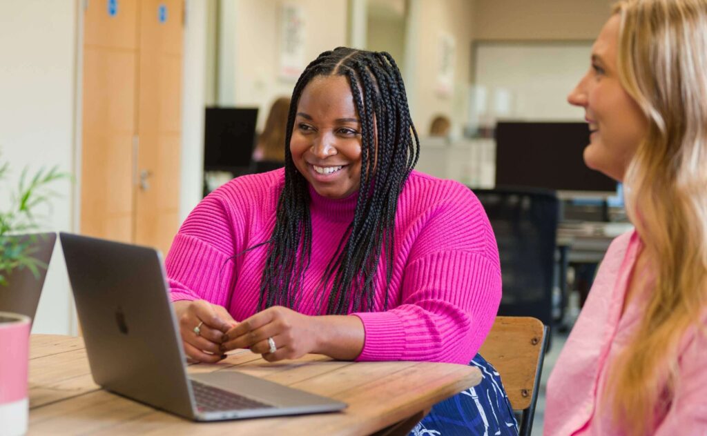 Women in pink jumper on laptop