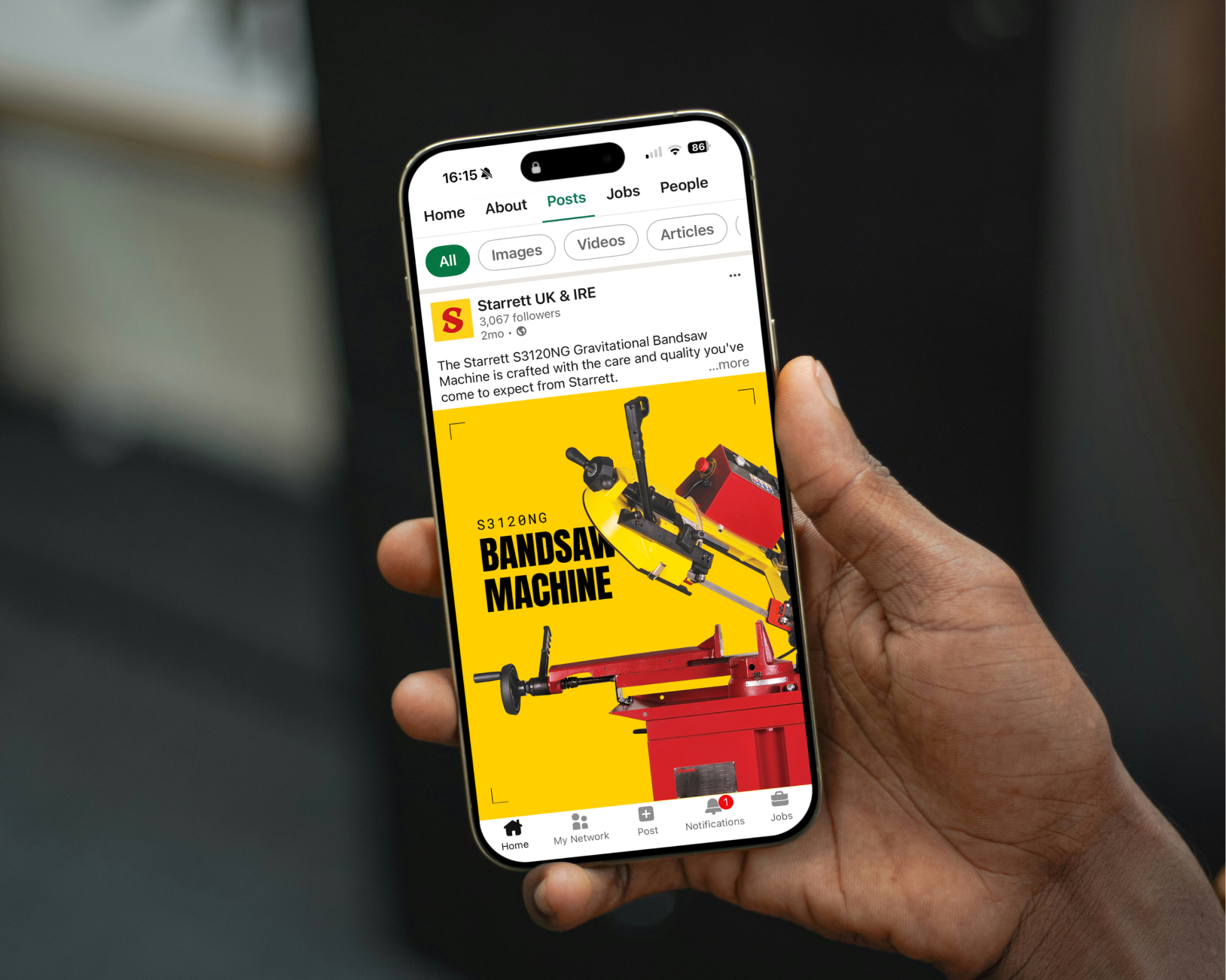 Hand holding smartphone showing Starrett B2B social media post